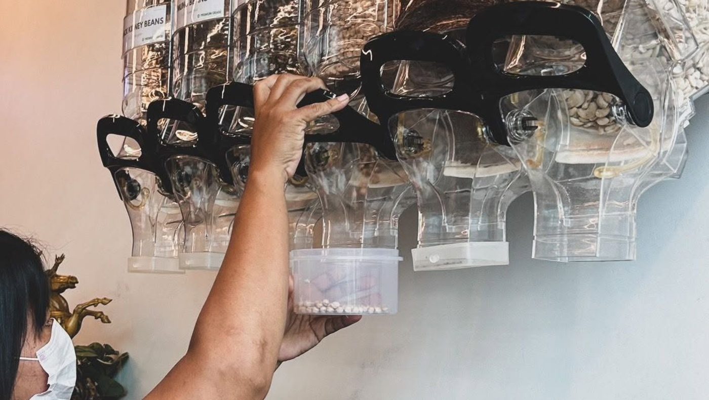 Filling a reusable container at the bulk refill station on Koh Samui